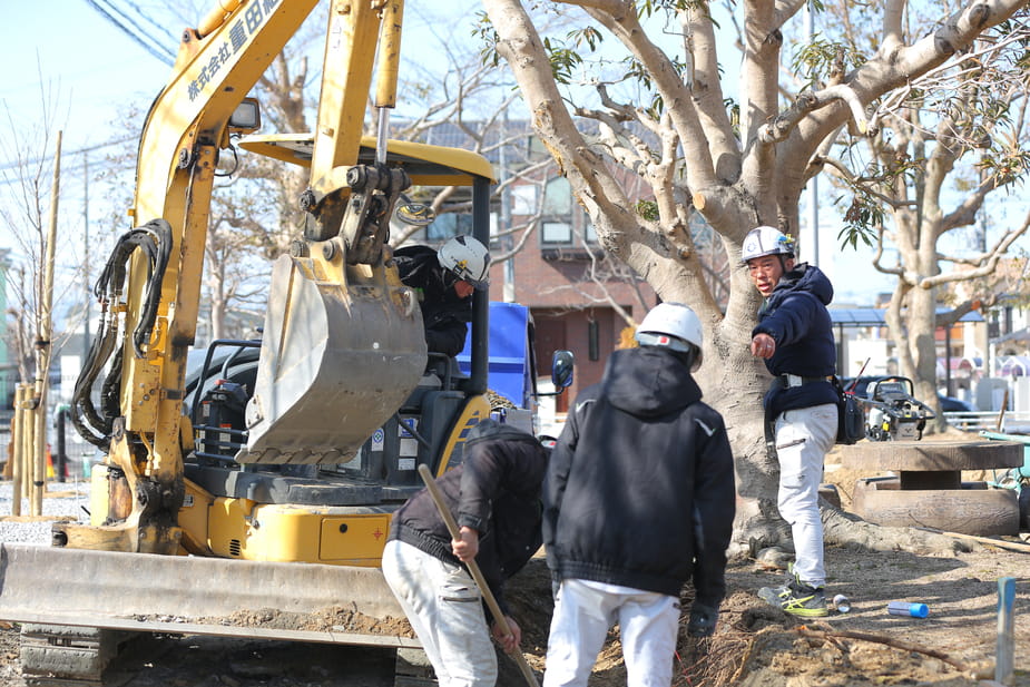 建設現場で作業員たちが協力しながら掘削作業を進めている