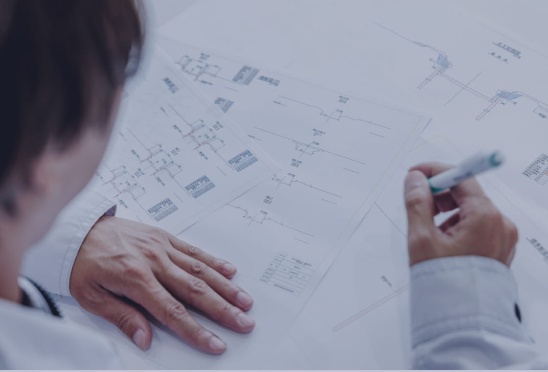 設計図を前にペンを持ちながら議論している様子